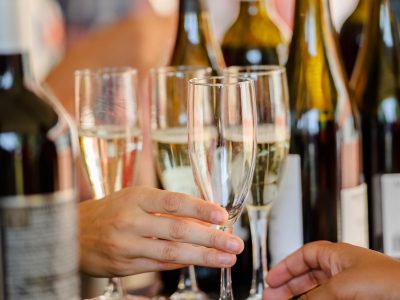 hands holding glasses of white wine