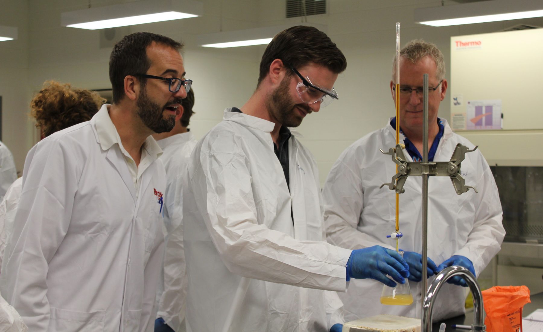 Three men working in a lab setting 