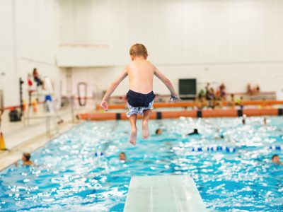 child jumps off diving board at Eleanor Misener Aquatic Centre at Brock University