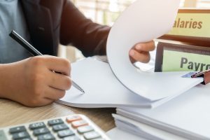 closeup of hands on a desk with papers and calculator
