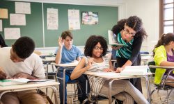 Teacher helping student in classroom