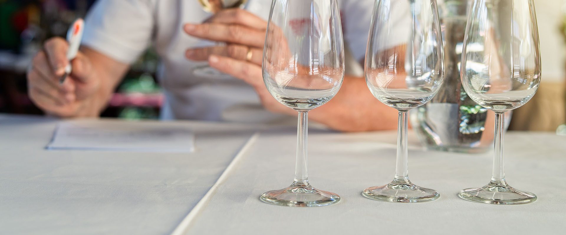 Close up on empty wine glasses on the table in front person tasting wine