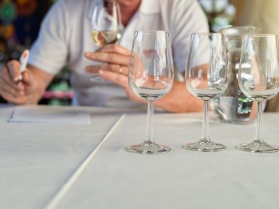 Close up on empty wine glasses on the table in front person tasting wine