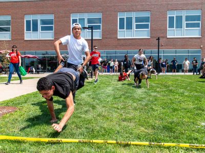 ESL Students doing outdoor wheelbarrow game on lawn