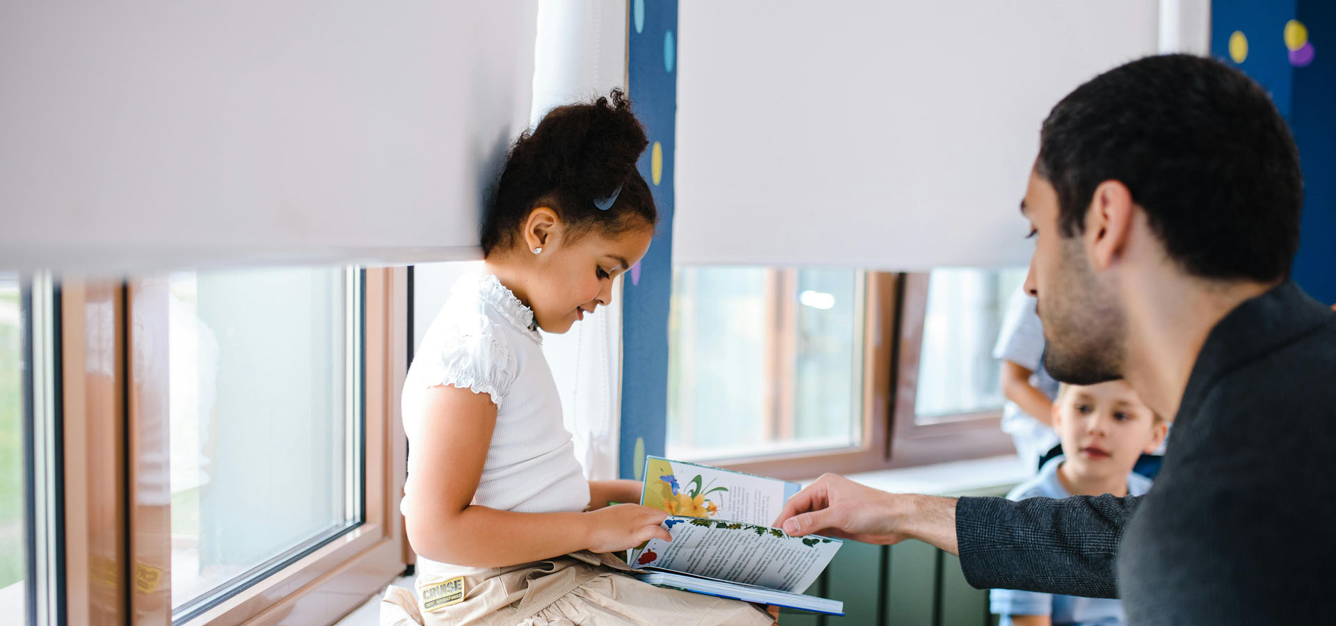 Reading Part 2 Teacher flipping a page with a student