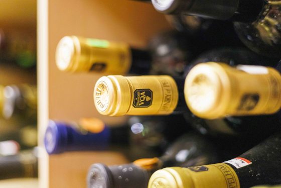 Wine bottles laying horizontally on a shelf stacked