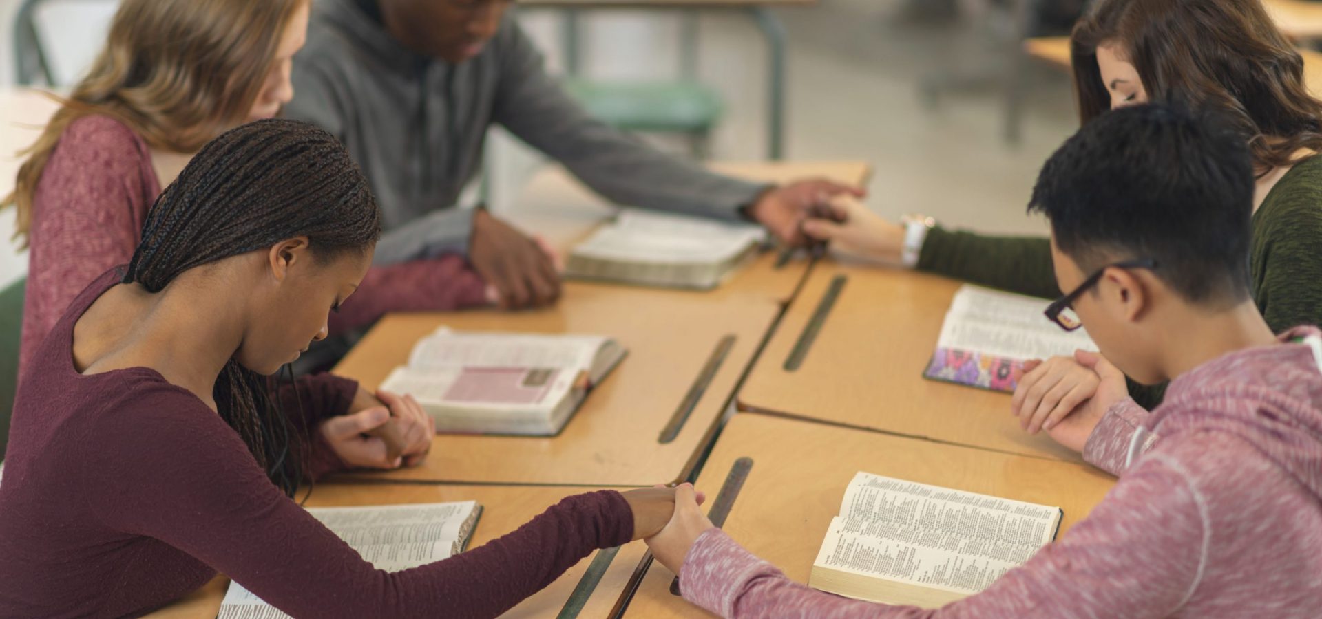 Five students praying together.