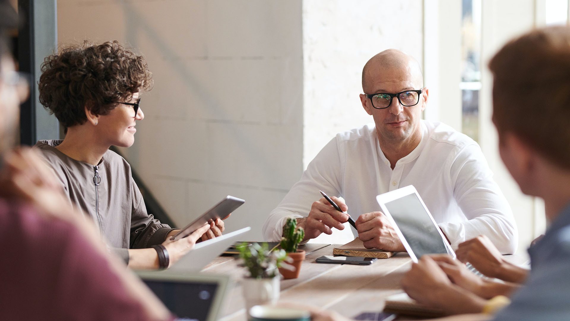 group of people in office around a desk sitting