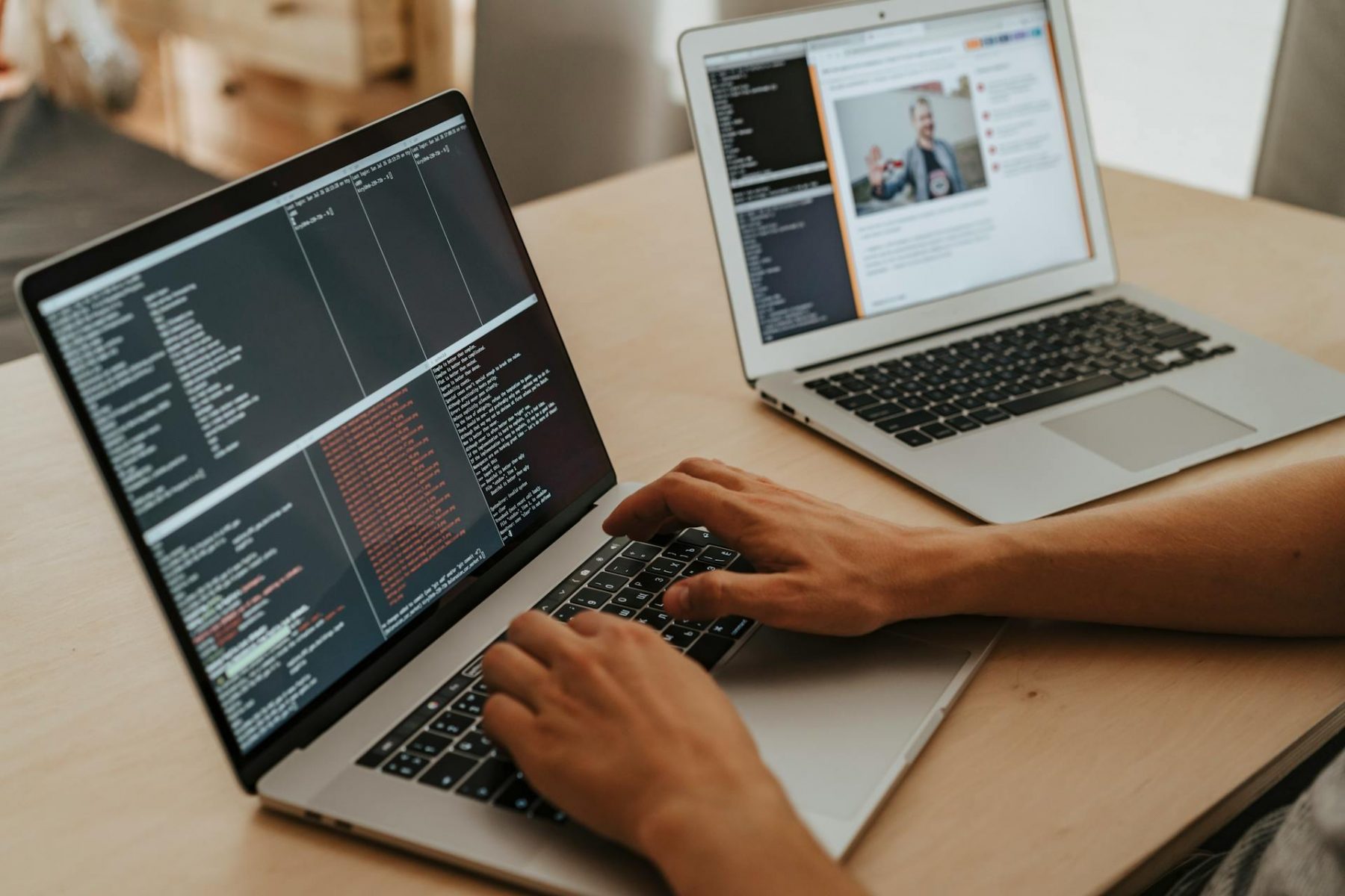 Hands typing on laptop with screen showing codes
