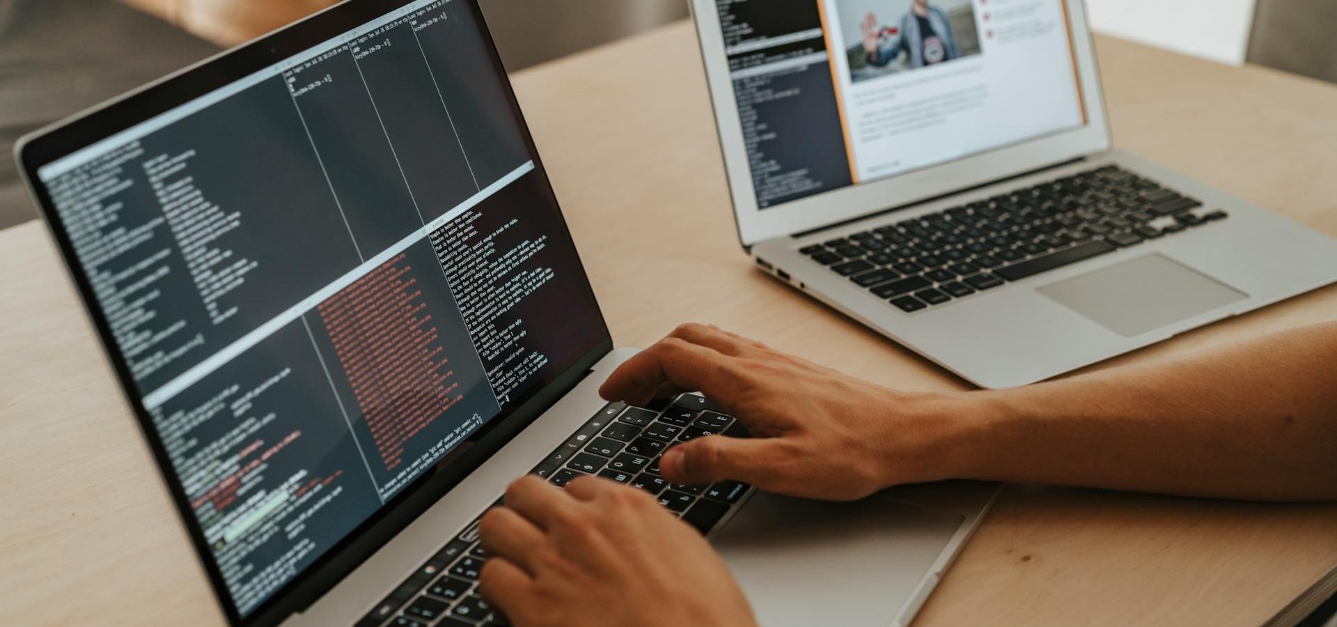 Hands typing on laptop with screen showing codes