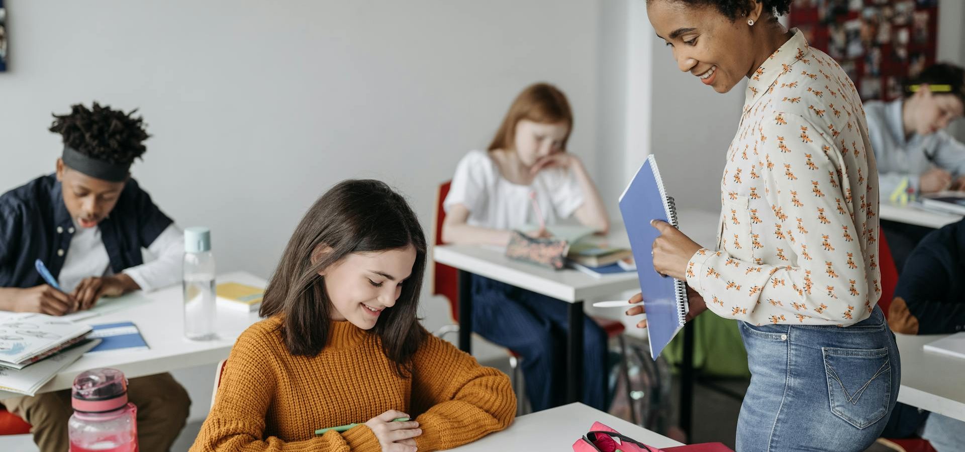 teacher assisting student in classroom