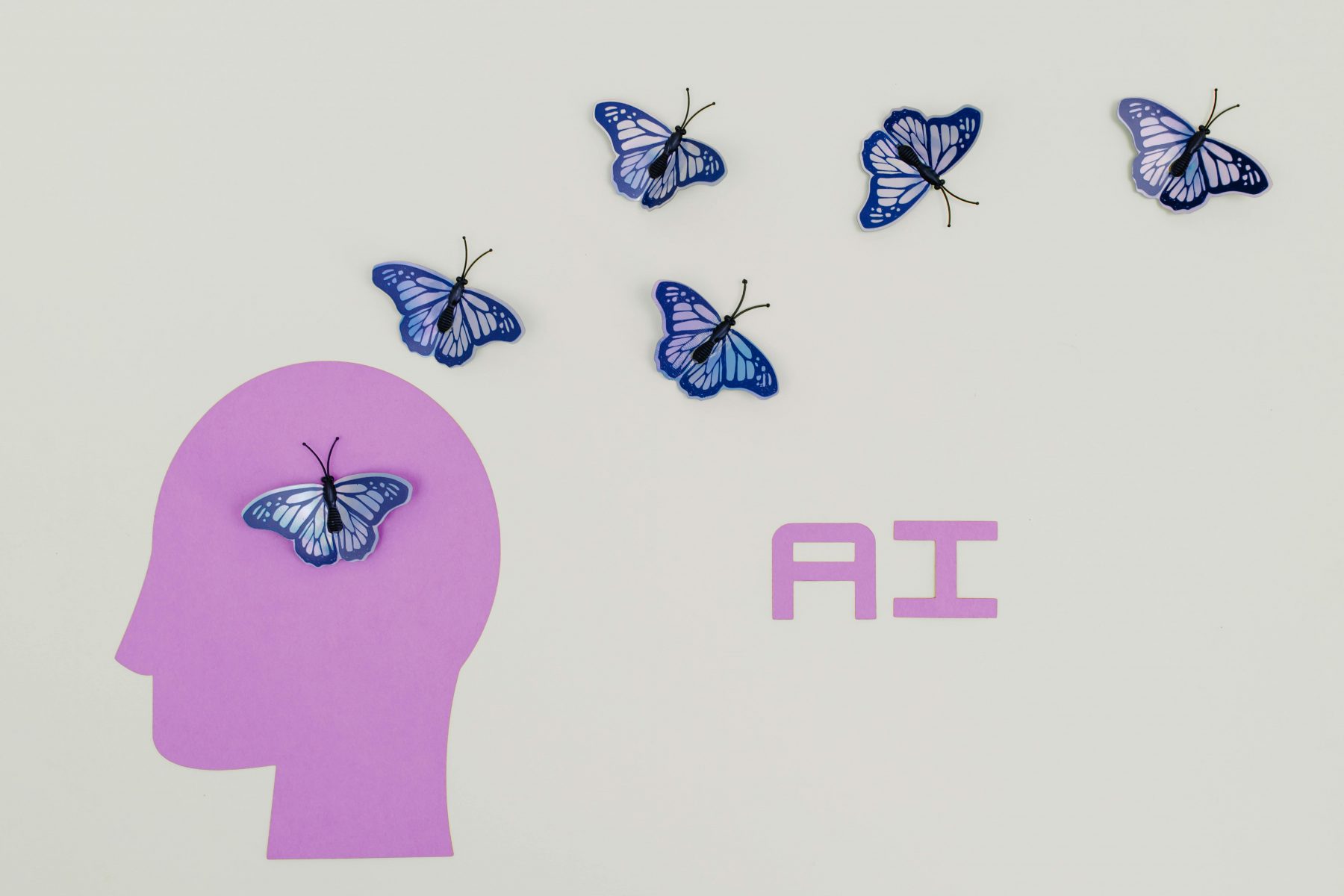 Graphic showing silhouette of head with butterflies and text that reads "AI"