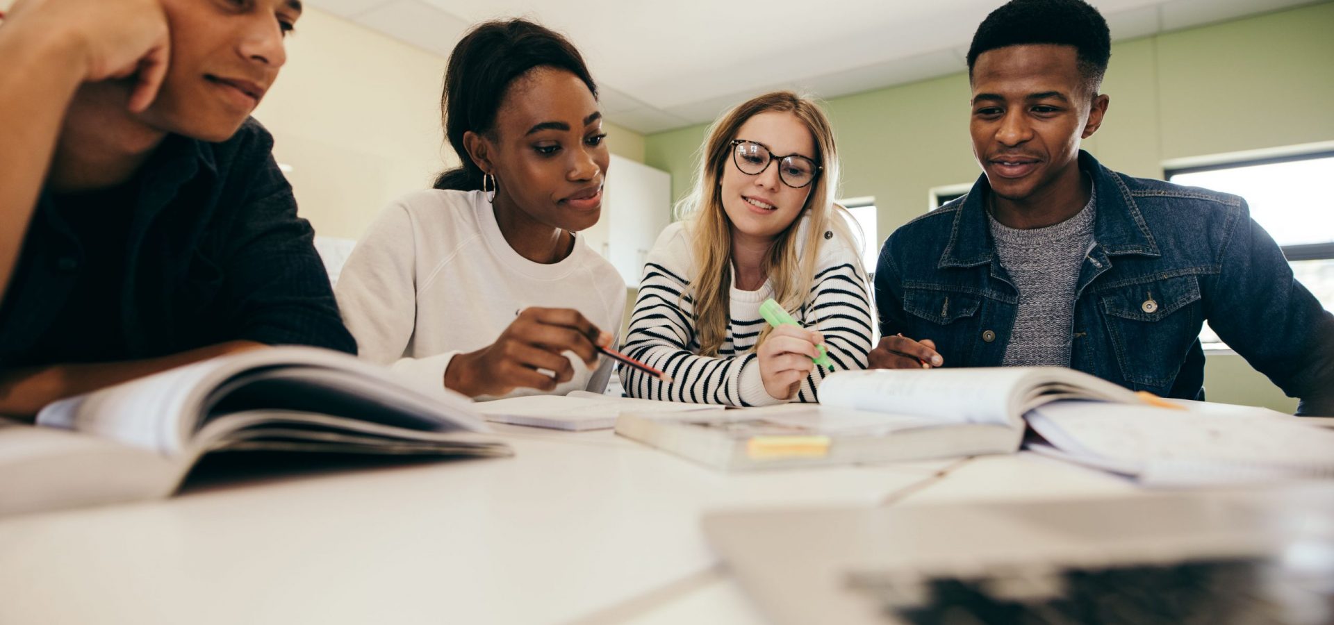group of four students around textbooks