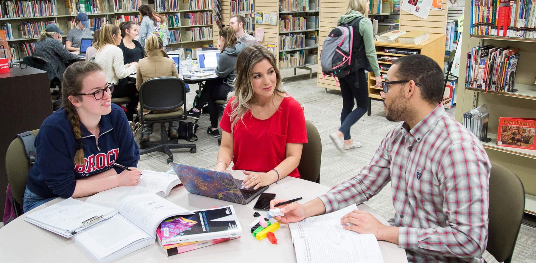 Brock University students working together at a table in a library.