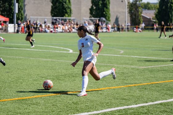 Women's soccer player gearing up to kick the ball
