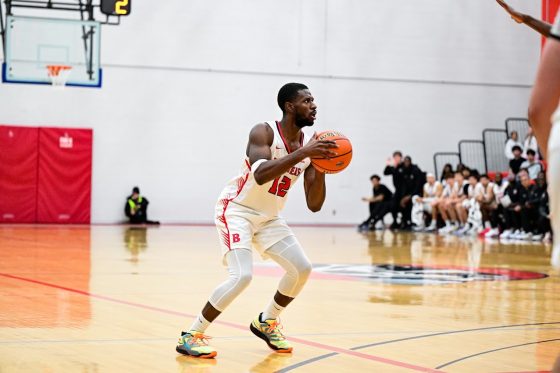 Men's basketball - a Brock basketball player holds the ball in mid-game