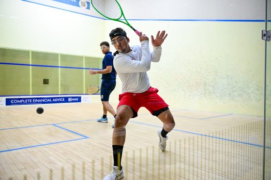 A man about to hit a ball in the game of squash.