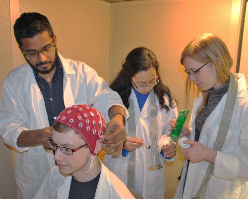 Brock students (from left) Janahan Selvanayagam, Harmonie Chan and Alanna Kozak prepare third-year student Sean Chisholm for observation in the Dwivedi Brain and Language Lab.