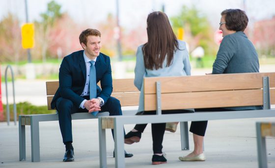 Group of professionals conversing on a bench