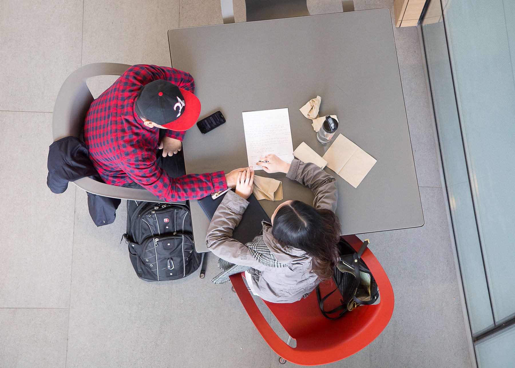 overhead view of 2 students studying paper