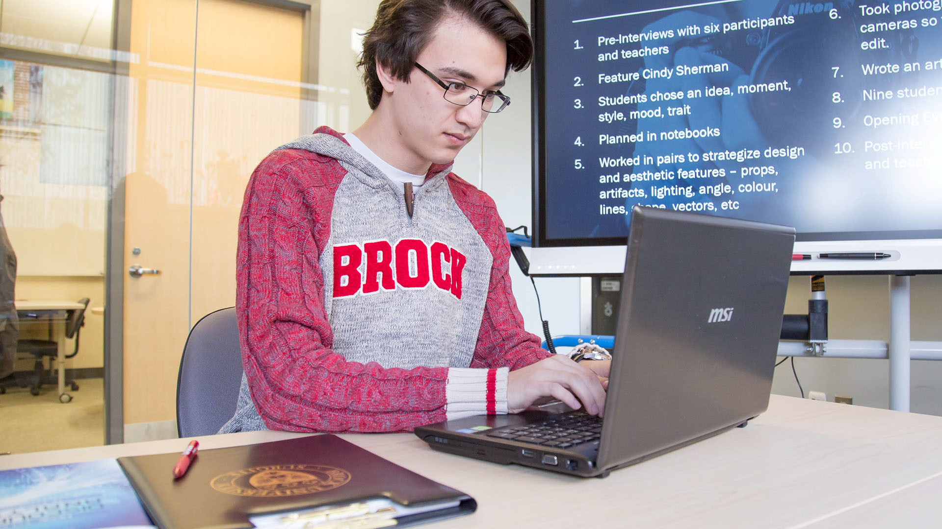 Graduate student works on a laptop