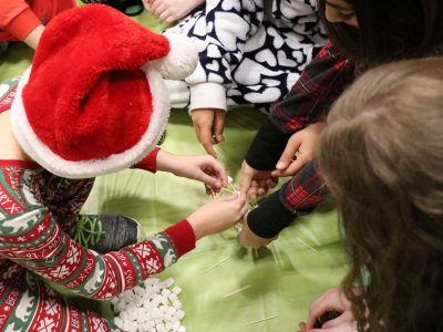 An elementary school student builds a marshmallow sculpture with Brock volunteers