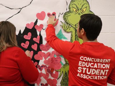 Brock volunteers decorate a Grinch display at the Holiday Extravaganza