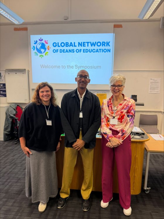 Three Deans stand together in a classroom. 