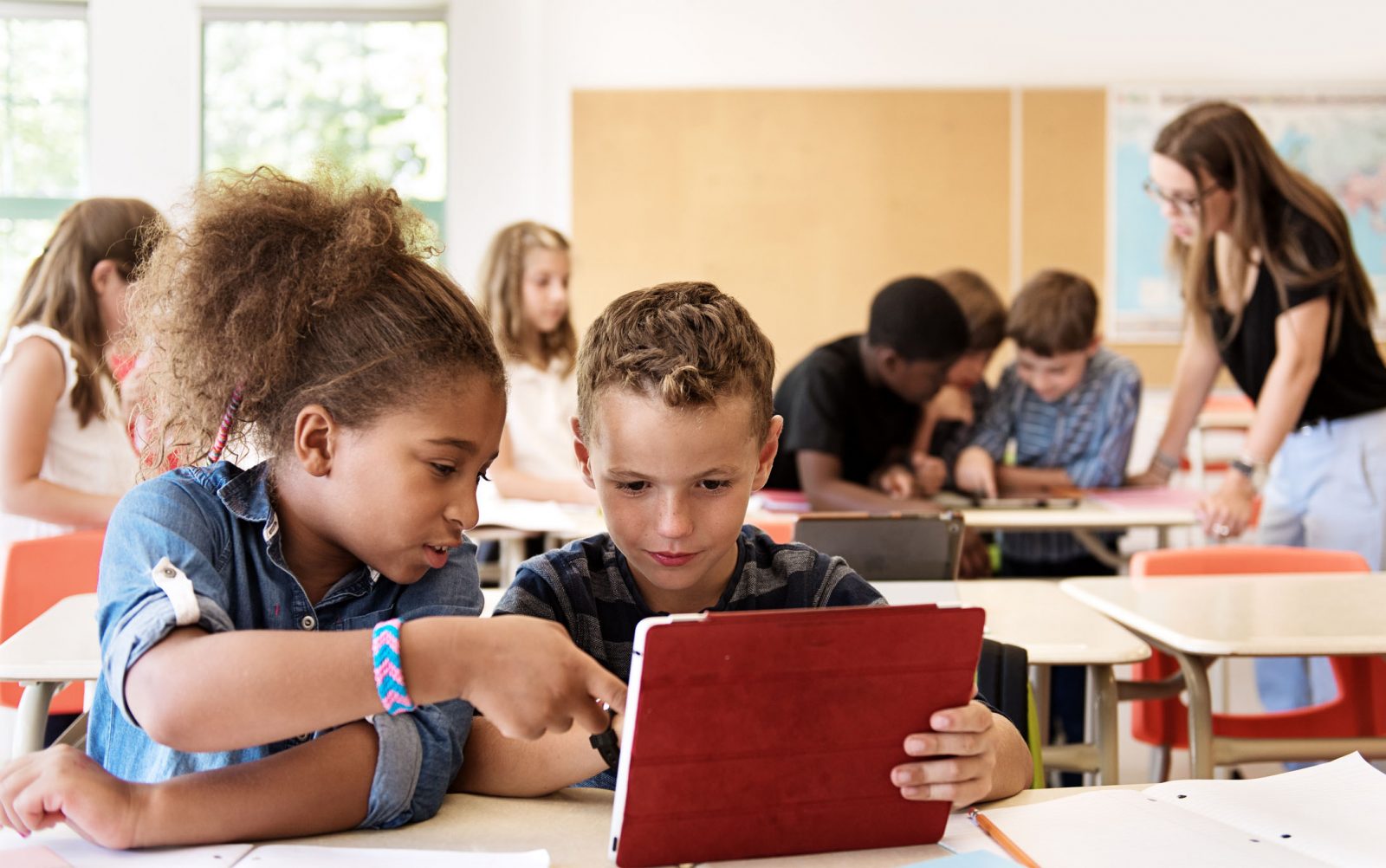 Two children interact in a classroom setting.