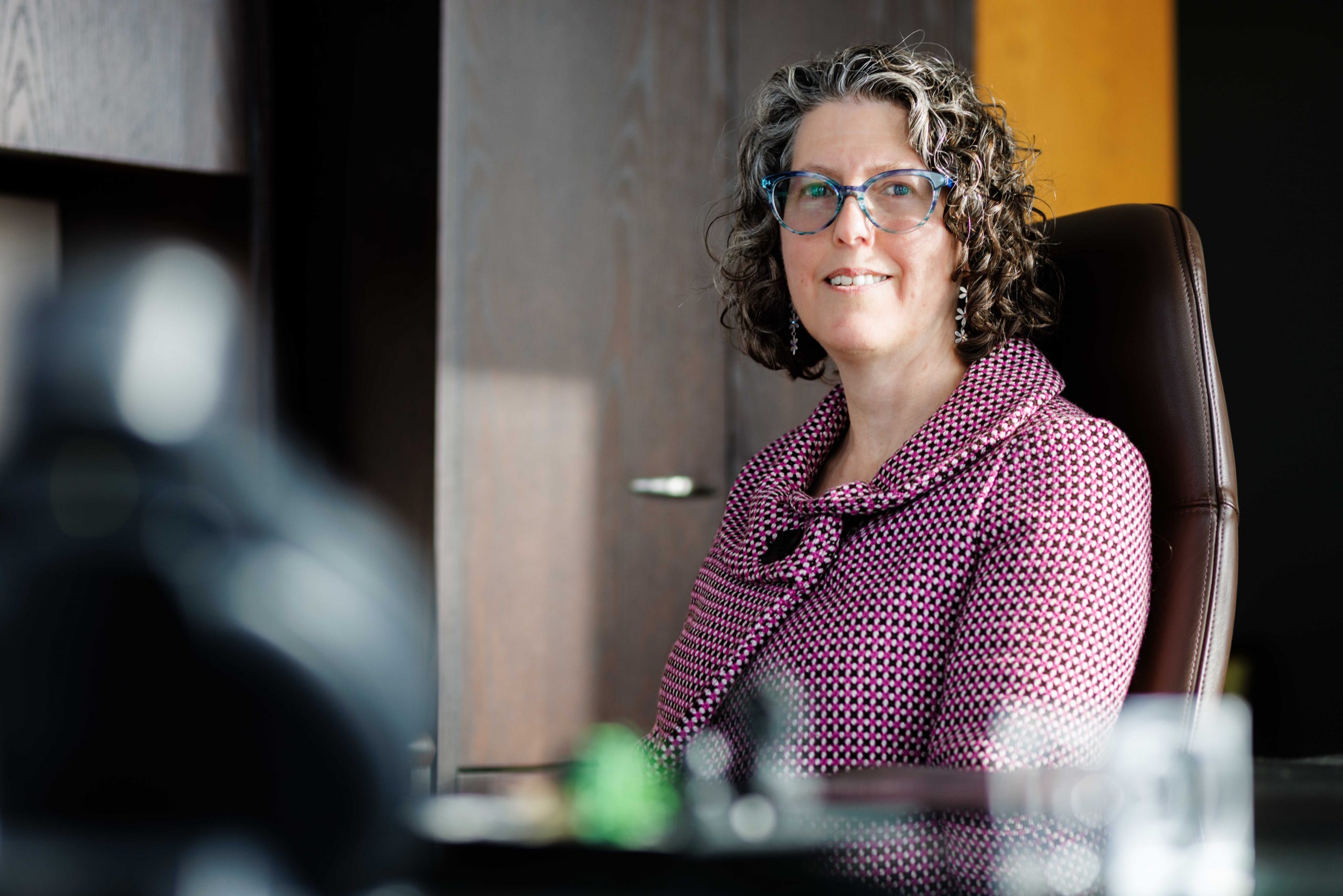 Acting Vice-President, Research, Michelle McGinn, sits in her office at Brock University, smiling warmly at the camera.