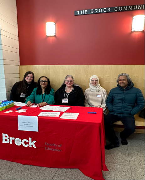 Five Brock University professors sit behind a table at the University.