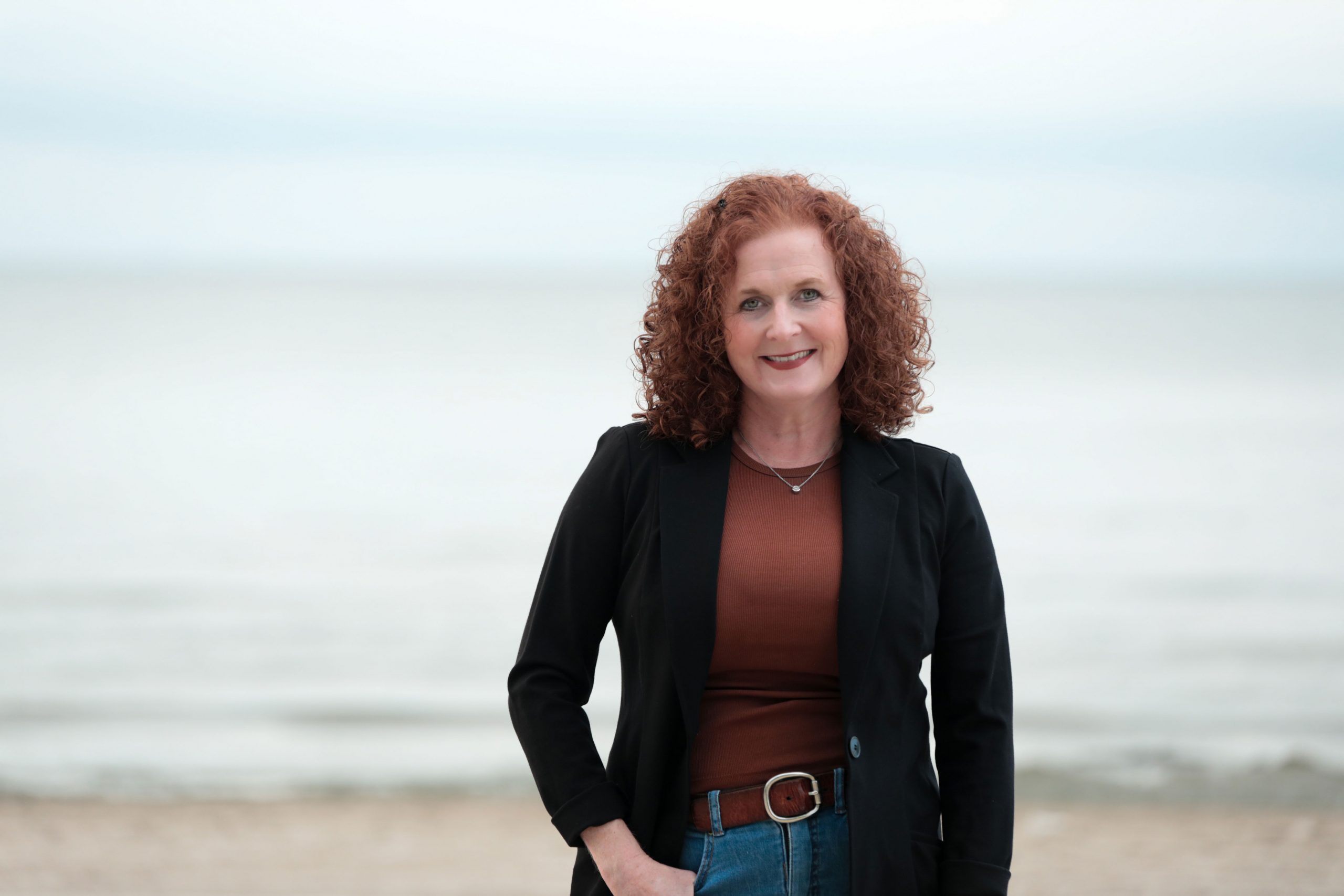 Shelley Griffin stands on a beach smiling.
