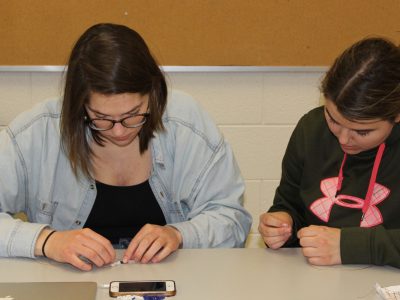 Two Brock students talking and beading in a Brock University class