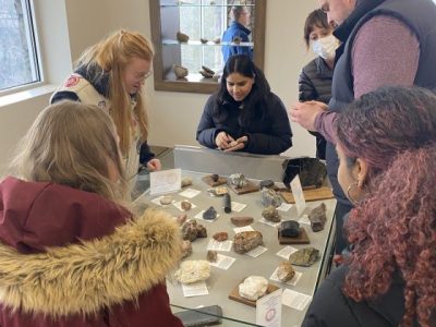 People standing around a table with rocks.