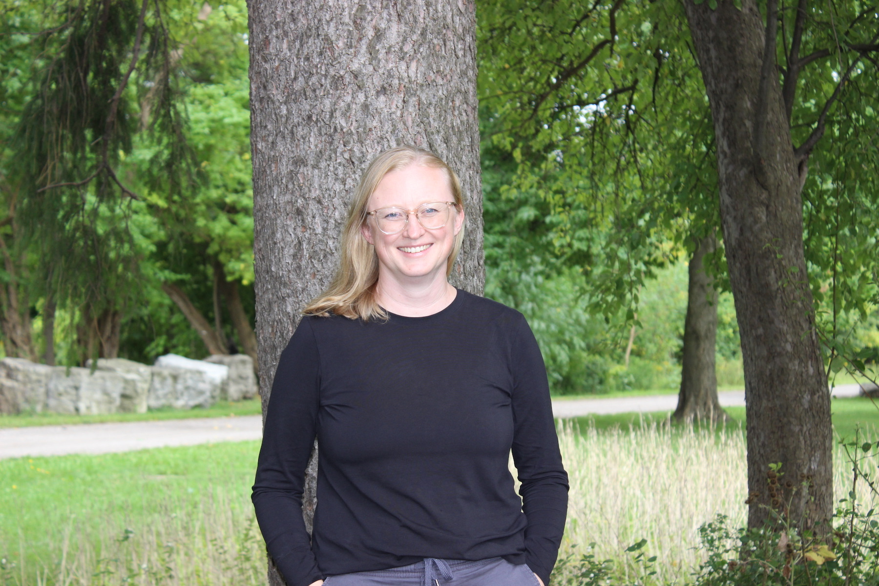 Natalie Seniuk standing in front of a tree.