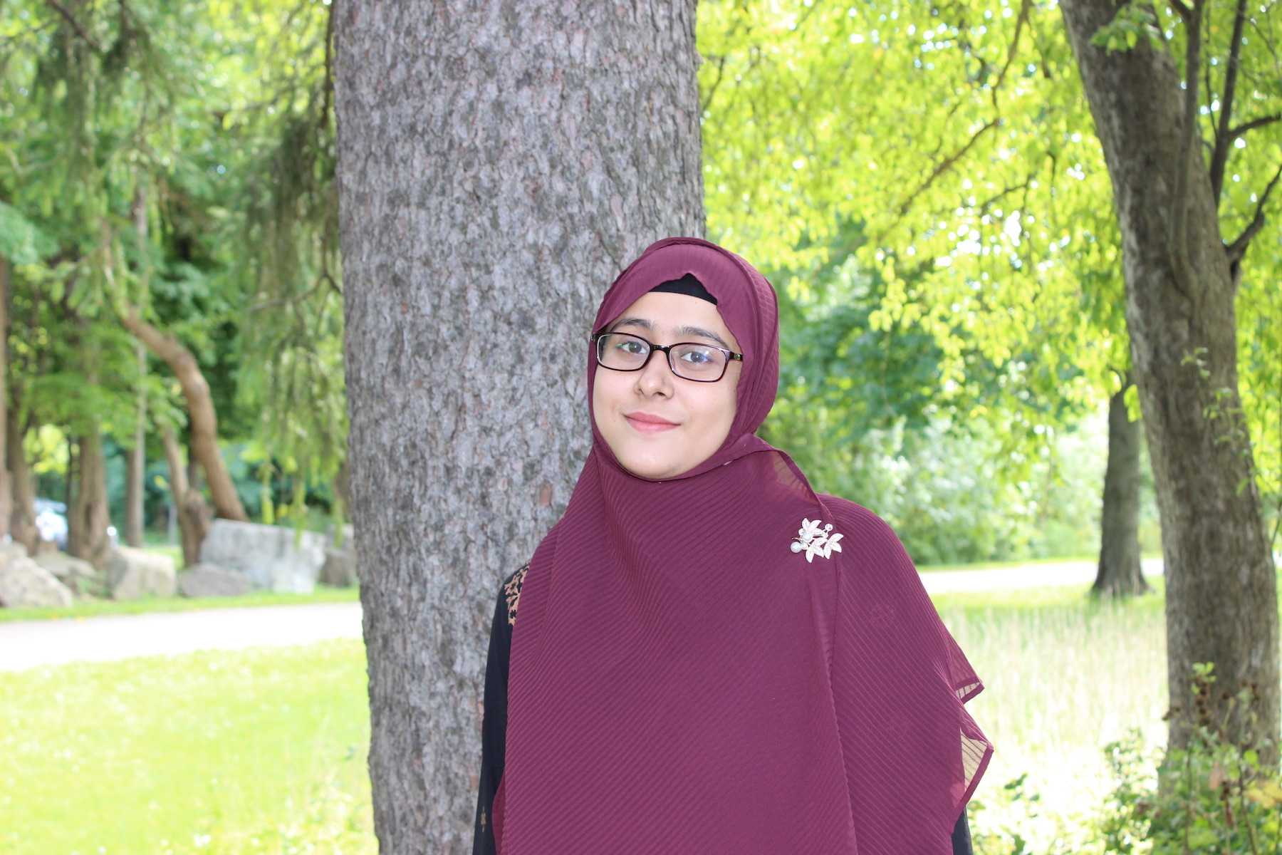 Sanjida Amin standing in front of a tree.