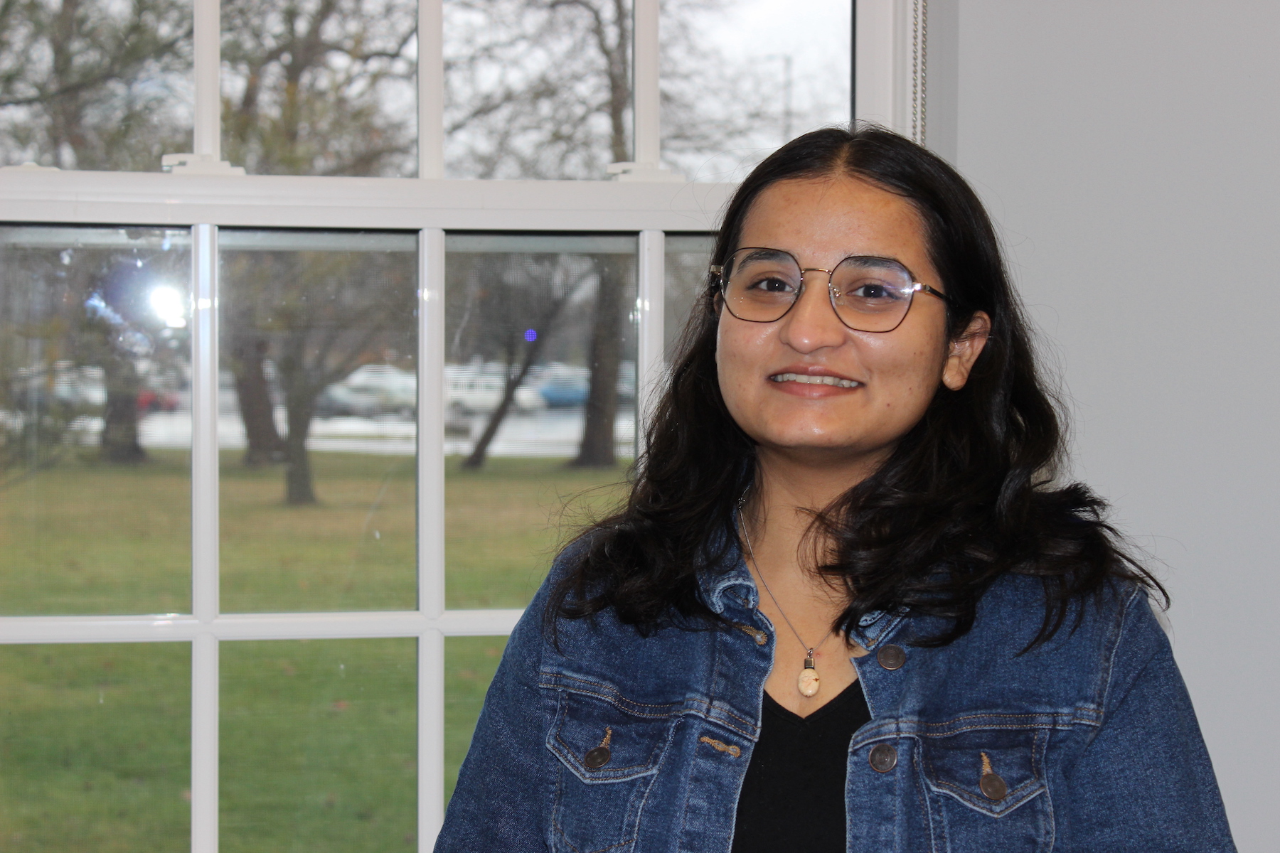 Zaara Momin standing in front of a window.