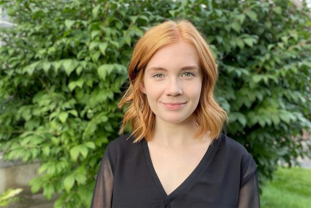 Kaitlyn Carr standing in front of a tree.