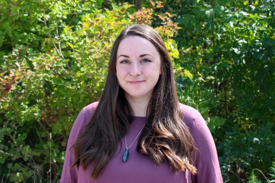 Madelaine Legault standing in front of trees.
