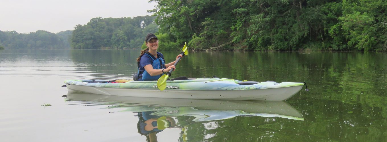 A person kayaks on an overcast day.