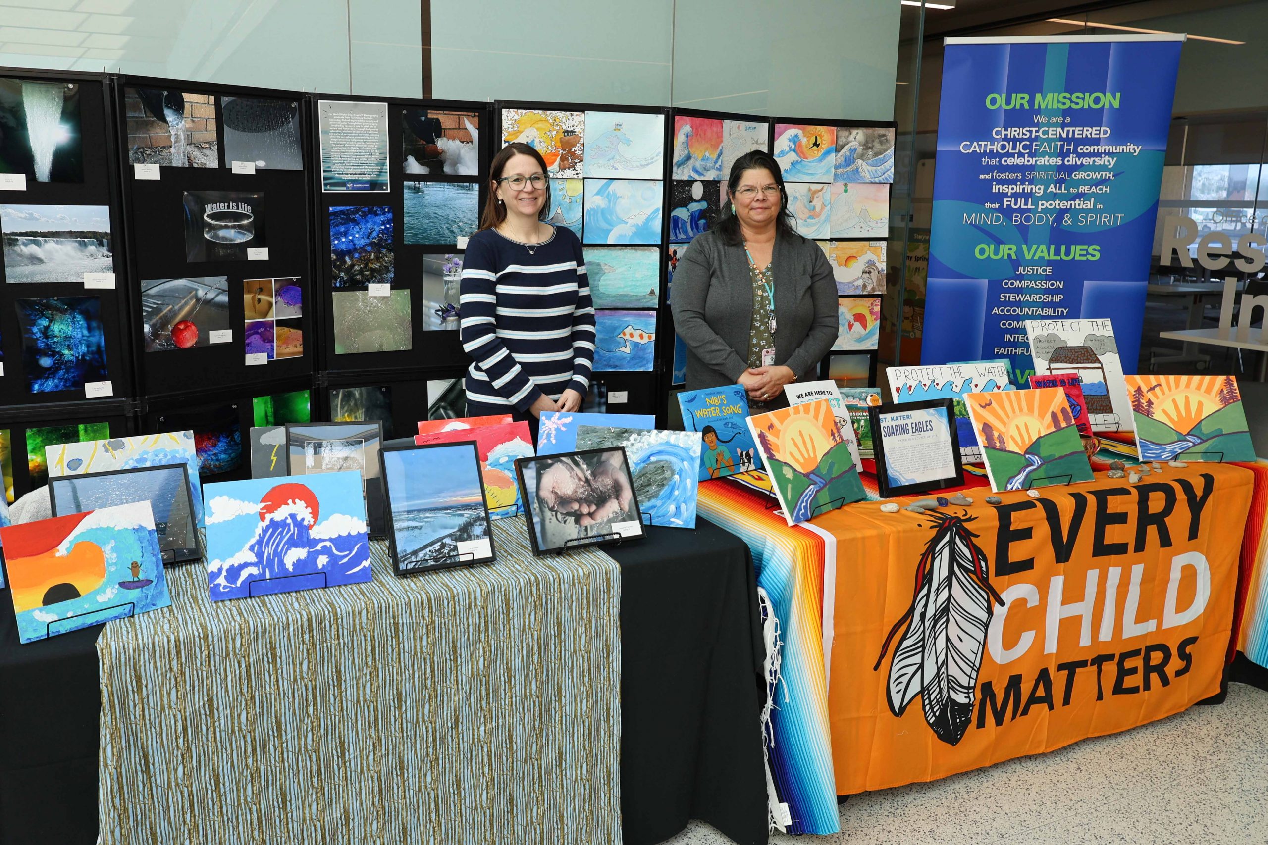The Niagara Catholic District School Board booth features colourful student artwork on a black backdrop.