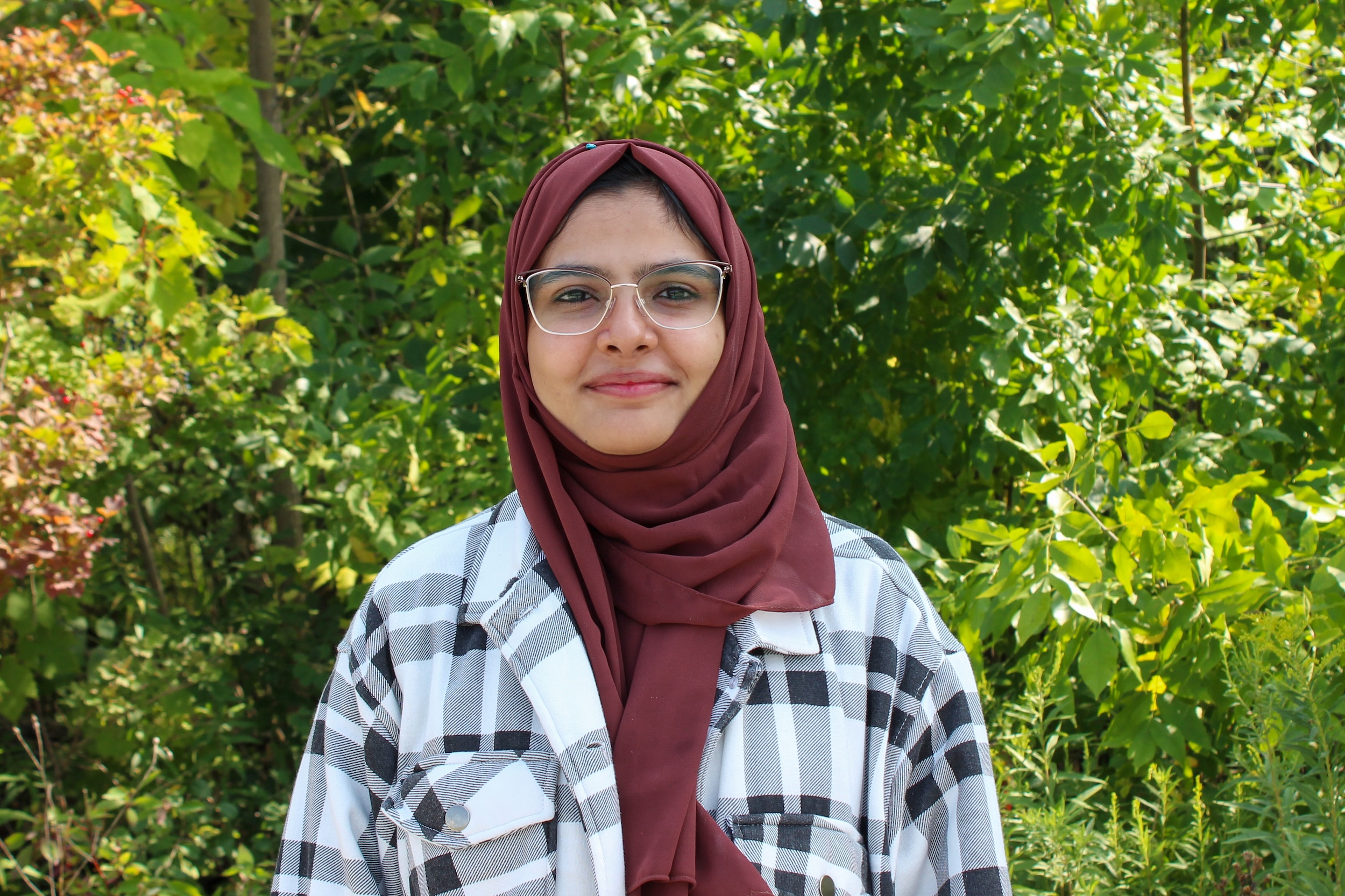 Qureshi Final Kinza Qureshi standing in front of trees.