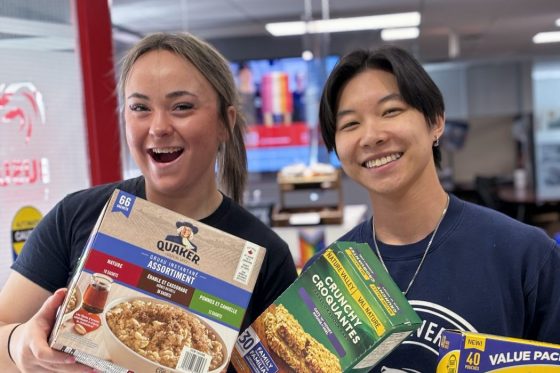 2 students holding donated snacks at Brock University