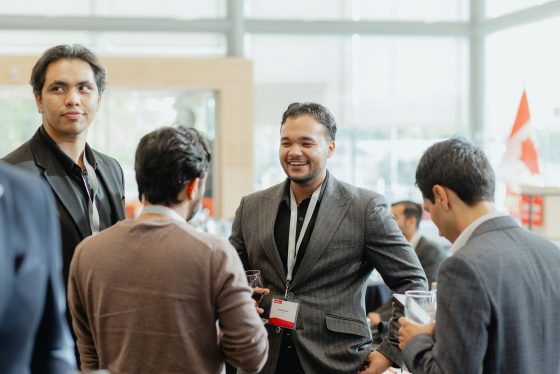 2025 Goodman Alumni Summit-0557_WEB A group of four men talking during a cocktail reception
