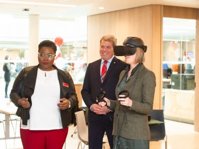 3 people one wearing VR glasses