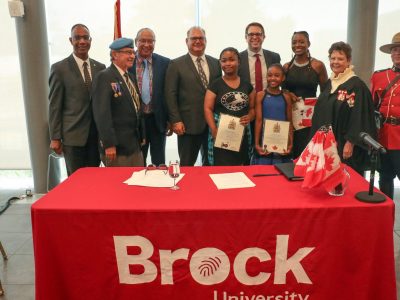 Minister sitting with Brock Delegates