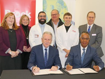 McMaster officials nd Brock University officials signing document
