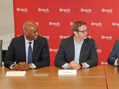 Minister sitting with Brock Delegates