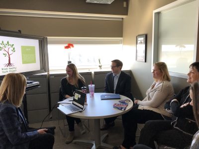 5 people sitting around a round table