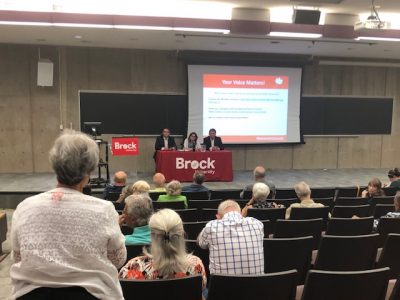 people in auditorium looking at a screen